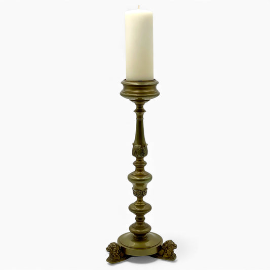 Vintage ornate brass candlestick with lion paw feet and decorative stem.